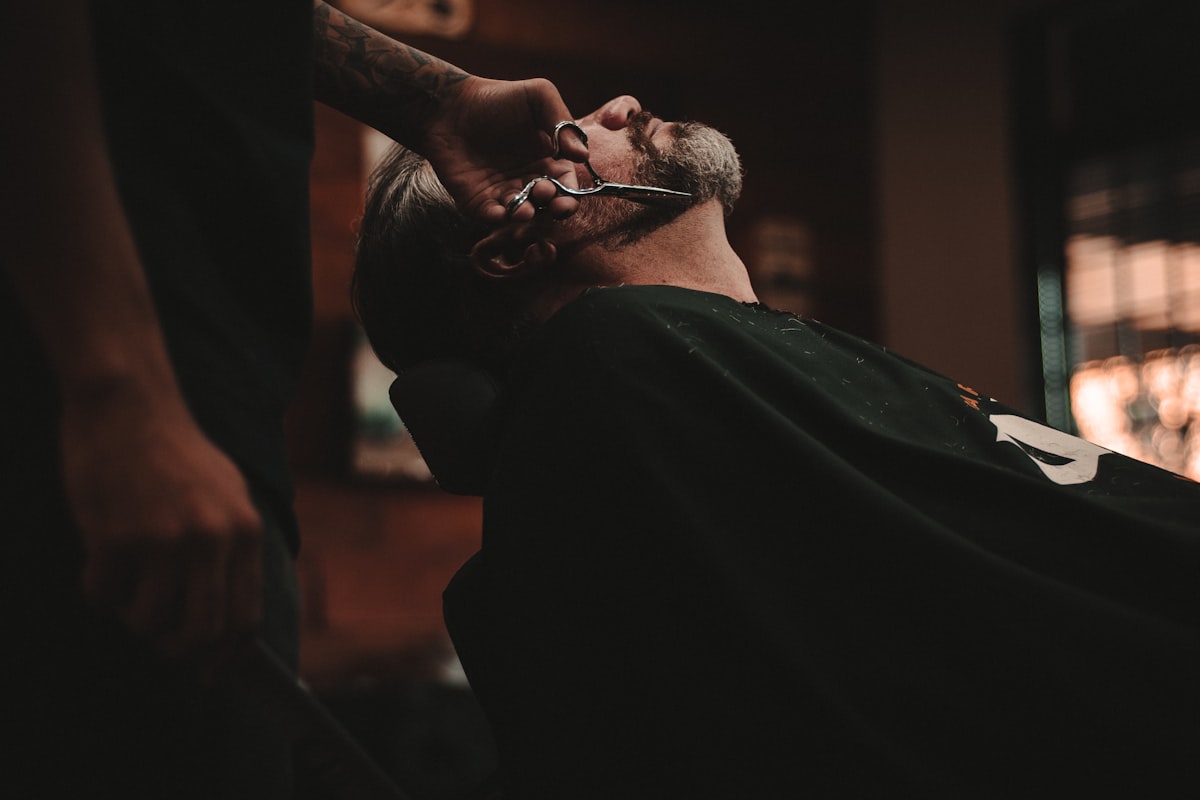 Barber shaping a men's haircut with scissors
